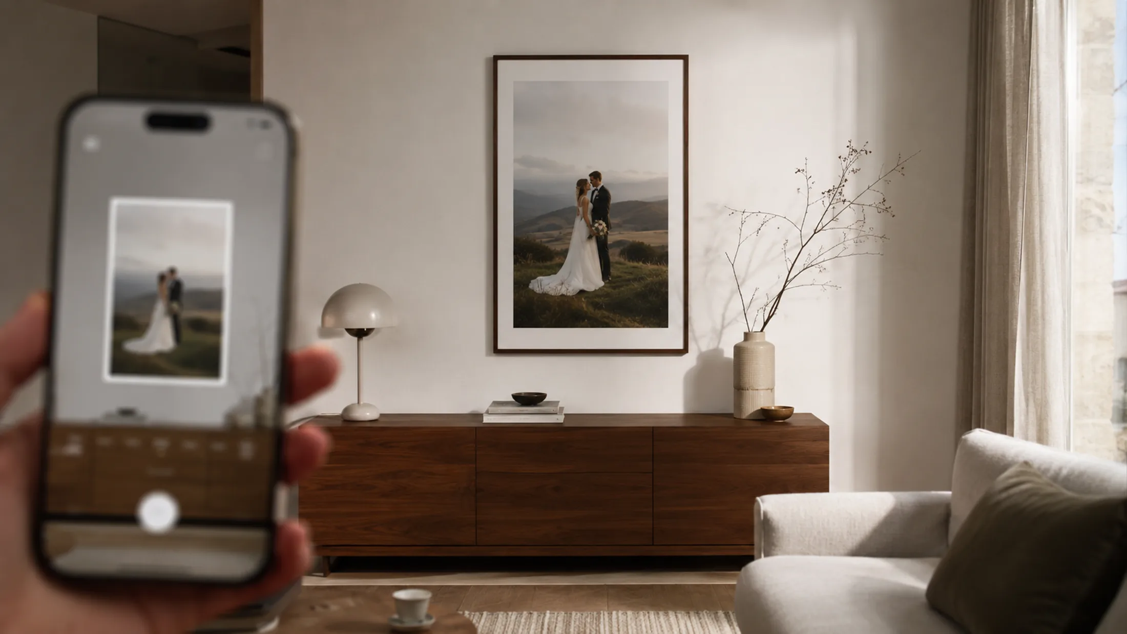 Wandbild über einem Sofa, daneben ein Smartphone mit AR-Vorschau